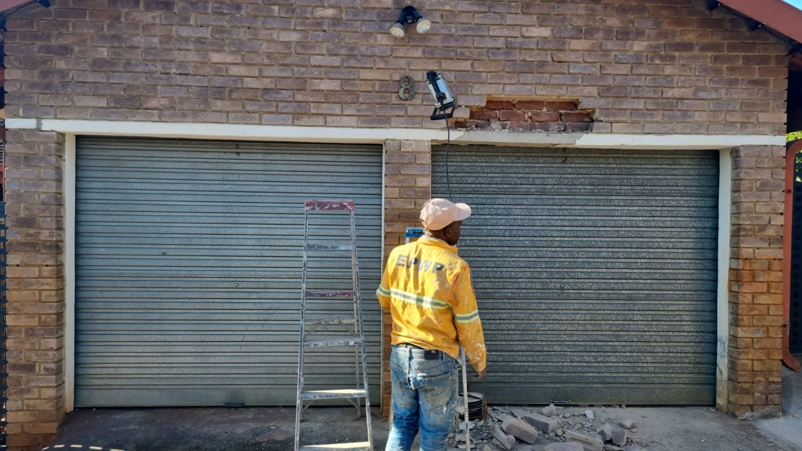 Garage doors before — twin tired roller shutters and exposed brickwork