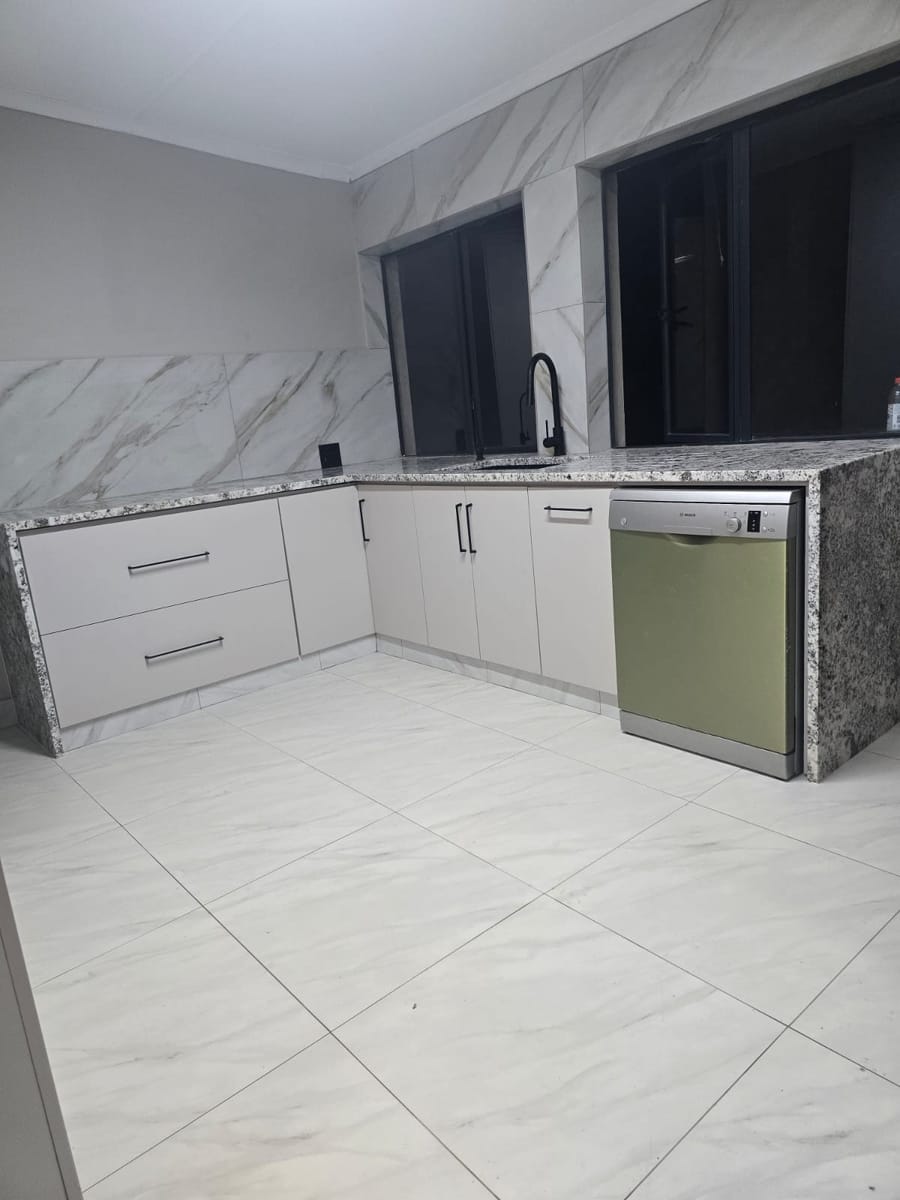 L-shaped kitchen units with drawers, granite counters and dishwasher space
